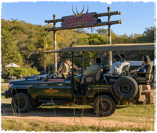 Game vehicle in front of large wooden entrance gate